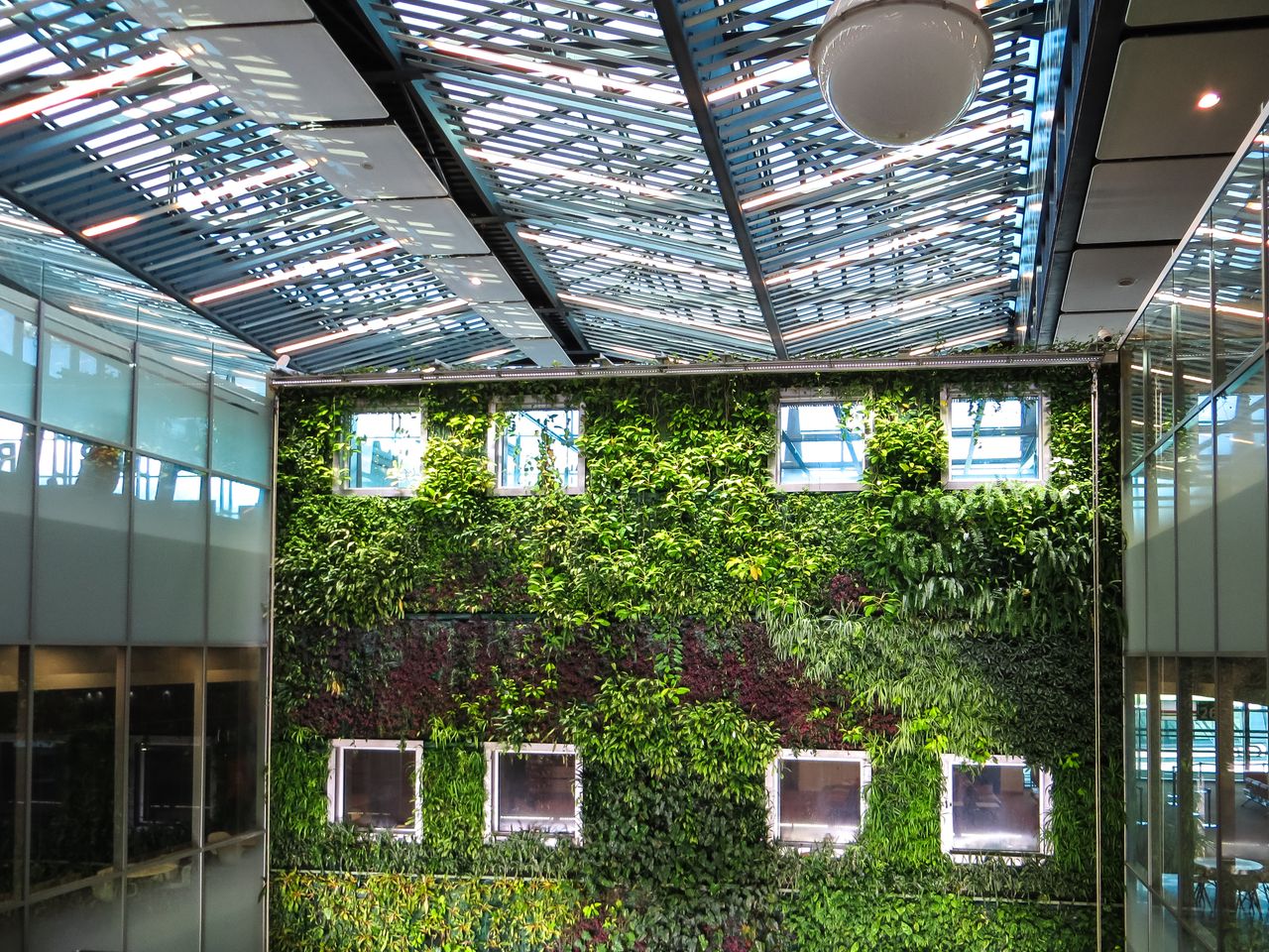 The Art of Drawing Readers In: Your attractive post title goes here Contemporary indoor space featuring a lush vertical garden and a sleek glass roof, blending nature with architecture.